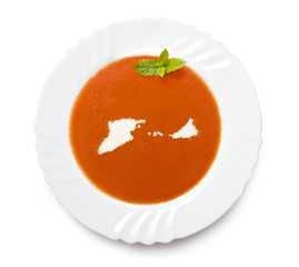 Plate tomato soup with cream in the shape of Midway Islands.(ser