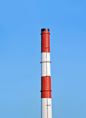 Chimney of industrial plant against blue sky background