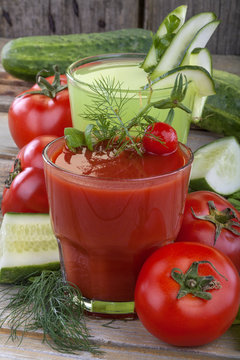 Healthy domestic tomato and cucumber  juices on a wooden table