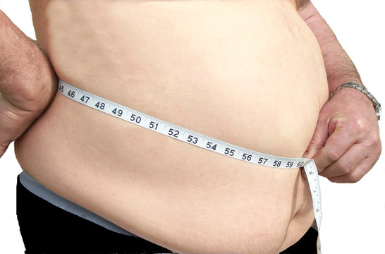 Obese man measuring his waist.