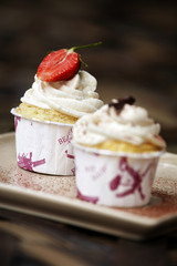 vanilla cupcake and milk cream with strawberry in paper cup