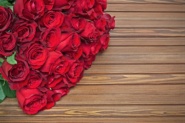 Colorful flower bouquet from red roses on wooden background.