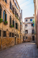Fototapeta premium Narrow canal among old colorful brick houses in Venice