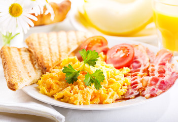 breakfast with scrambled eggs, juice and fruits