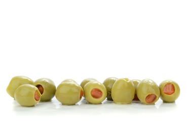 A row of green olives on a white background with copy space