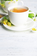 Tasty herbal tea with linden flowers on wooden table