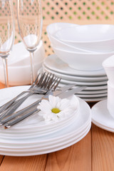 Set of white dishes on table on light background