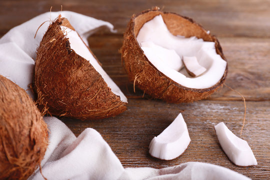 Broken coconut with napkin on wooden background