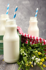 Milk in bottles with paper straws on table