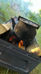 Black metal touristic teapot on an outdoor fireplace