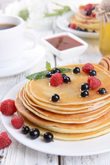 Sweet pancakes with berries on table close-up