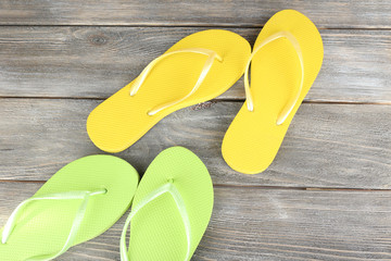 Colorful flip-flops on wooden background