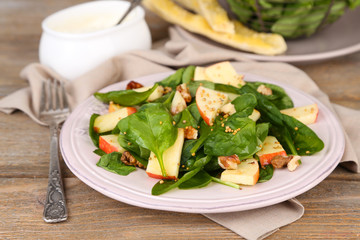 Green salad with apples, walnuts and cheese on wooden