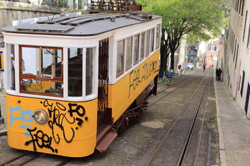 Naklejka na ściany i meble Yellow tram with graffity in lisbon