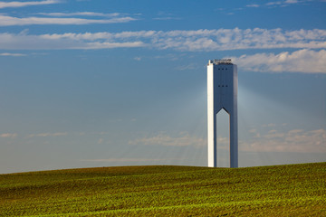 Solar Tower with rays  - thermo-solar power - blue sky and green