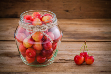 Rainier Cherries in glass on wooden background