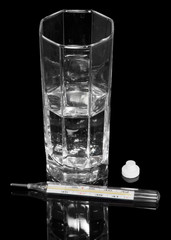 Thermometer, pills and glass of water