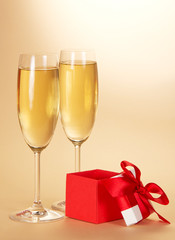 Two wine glasses with champagne and gift
