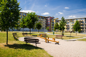 Children playground in nature in front of block of flats