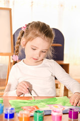 Cute little girl drawing with paint