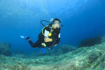Naklejka na ściany i meble Young woman scuba diving