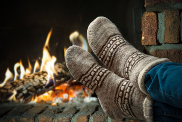 Feet in wool socks warming at the fireplace