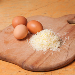 Grated parmesan and eggs on table