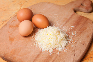 Grated parmesan and eggs on table
