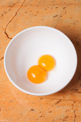 yellow egg yolks in a white bowl