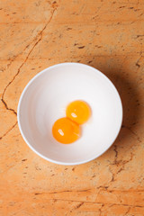 yellow egg yolks in a white bowl