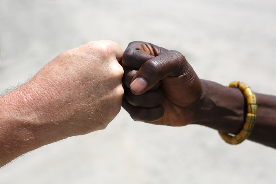 Hand greeting between a Caucasian and an African