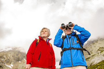 Senior hikers with binoculars