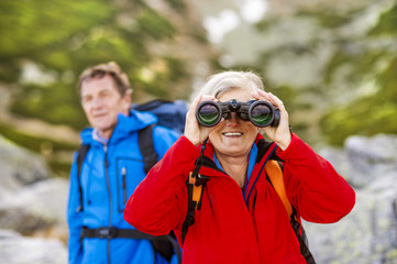 Senior hikers with binoculars