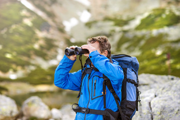 Senior hiker with binoculars