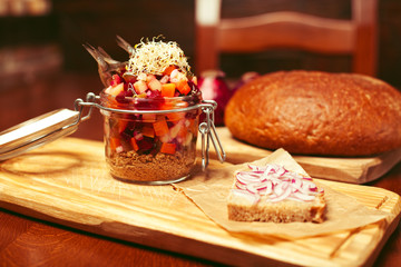 Mason jar with salad: pieces of vegetables and anchovy