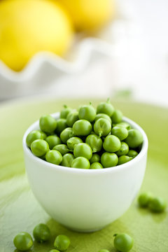 Fresh green peas in a white bowl