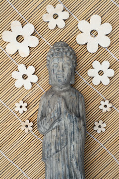 Stenen  grijze Boeddha met houten bloemen