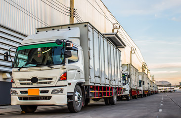 Fototapeta na wymiar White trucks parked on a parking places in warehouse