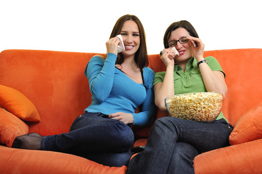 female friends eating popcorn and watching tv at home