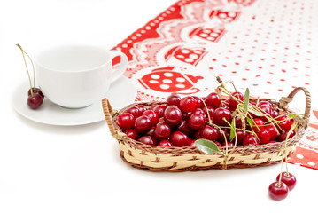 cup and juicy red cherries on the table