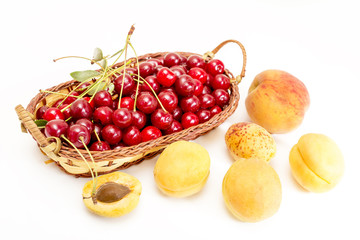 red cherries in a basket and ripe apricots