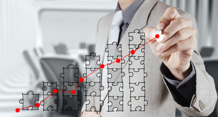 businessman hand puzzle charts with new modern computer and busi