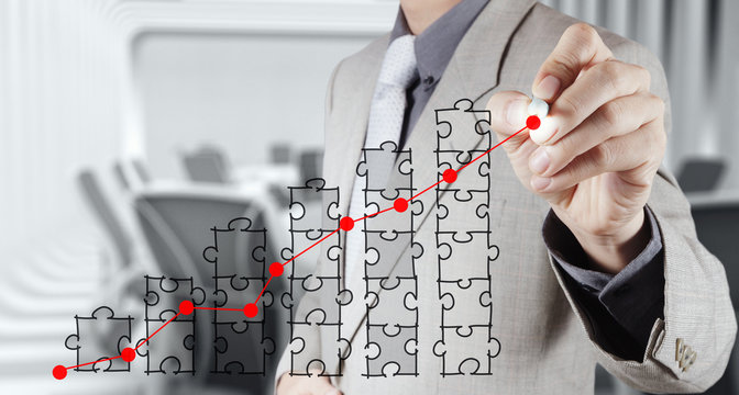 businessman hand puzzle charts with new modern computer and busi