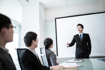 businessman giving a presentation to his colleagues
