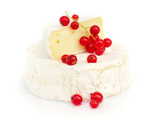 Camembert cheese with red currants on white background
