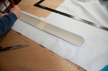 person drawing around stencil on textile