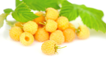 Fresh yellow raspberries with leafs on white background