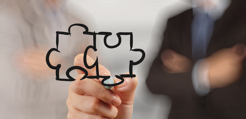 businessman hand drawing Partnership Puzzle Concept