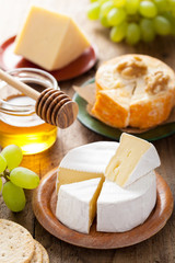 cheese plate with camembert, cheddar, grapes and honey