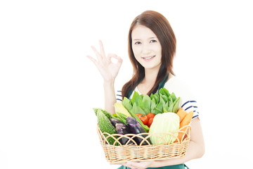 Obraz na płótnie Canvas 野菜を持つ笑顔の女性